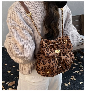 Detailed back view of a quilted leopard print backpack with gold chain straps and twist lock