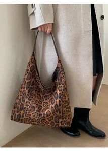 Détail du sac hobo à imprimé léopard avec anses en cuir marron et texture souple