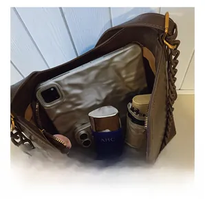 Internal view of a spacious brown bucket bag with iPad, phone, and folding umbrella inside