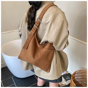 Detail view of brown suede shoulder bag with adjustable silver buckles and pocket