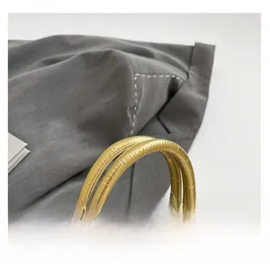 Close-up of golden embossed crocodile leather handbag with sturdy double round handles