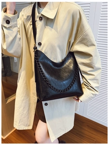 Detail of black faux leather hobo bag with thick chain strap and adjustable shoulder strap