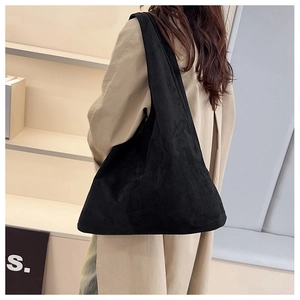 Minimalist black oversized suede hobo tote bag styled with a beige winter coat