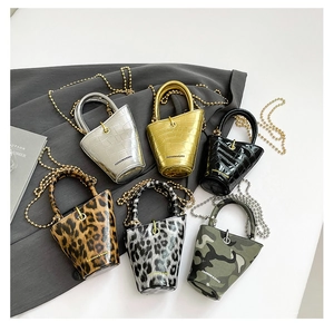 Mini cylinder bags in leopard print, crocodile textures, and camo with metal chain straps