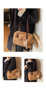 Detail of khaki canvas tote bag with leather straps and plush bear charm decoration