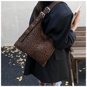 Detail of adjustable shoulder strap with silver buckle on leopard print canvas bag