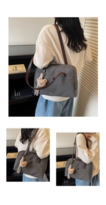 Detail of grey canvas tote bag with brown leather straps and a plush bear charm