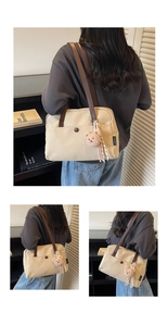 Detail of canvas tote with brown leather strap and cute bear charm in home setting
