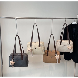 Detail of canvas tote bags in four colors with brown straps and cute bear charms