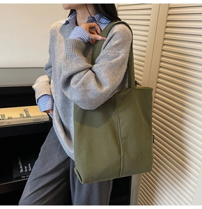 Close-up of olive green corduroy tote bag worn on shoulder for casual autumn outfit