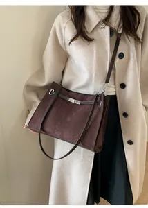 Detail of dark brown suede tote bag with silver buckle and elegant thin shoulder strap
