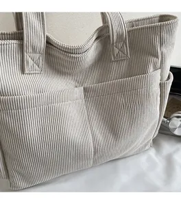 Détails d'un sac cabas en velours côtelé avec deux poches frontales et compartiment