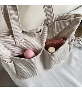 Gros plan du sac cabas en velours côtelé beige avec poches et rangement