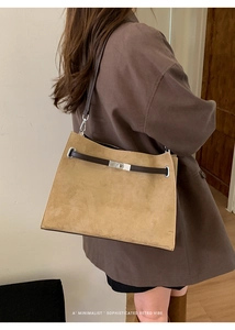 Side view of a retro khaki suede tote bag with brown leather straps on a model