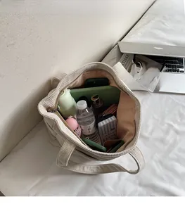 Détail intérieur du grand sac en velours côtelé montrant l'espace pour ordinateur et objets