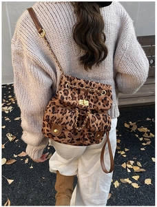 Detail eines gesteppten Rucksacks mit Leopardenmuster, Goldkette und Metalldrehverschluss