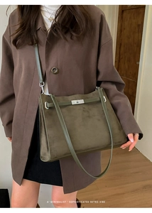 Detail view of olive green suede tote bag featuring signature silver turn-lock and strap