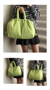 Detail view of large neon green padded nylon tote bag with drawstring closure and soft texture