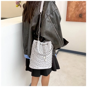 Detail der grauen Beuteltasche mit silbernen Punk-Nieten und Metallketten-Schultergurt