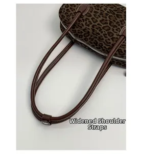 Close-up of widened brown leather shoulder strap on retro leopard print baguette bag