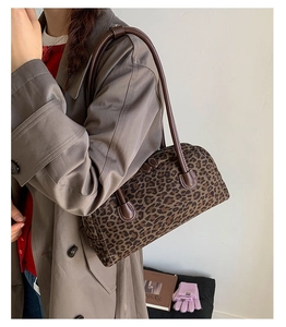 Detail view of leopard print baguette shoulder bag with leather handles and zip closure