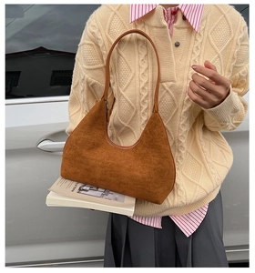 Detail of caramel brown suede hobo bag with smooth curved lines and matte texture