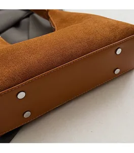Detail of vintage suede shoulder bag bottom with protective silver metal studs