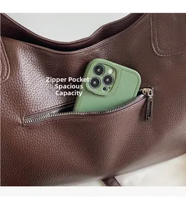 Macro detail of dark brown leather tote featuring a functional back zipper pocket for phone
