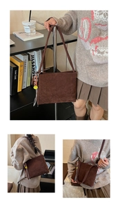 Dettaglio borsa minimalista in pelle scamosciata marrone con ciondolo smiley e nappe