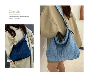 Detail van vintage denim tote bag met contraststiksels en verstelbare metalen gespriem