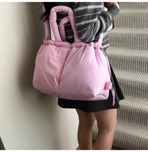 Close-up of pink quilted tote bag showing padded fabric and drawstring side detail