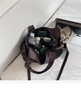 Detailed interior of a large brown tote bag showing multi-pocket storage capacity