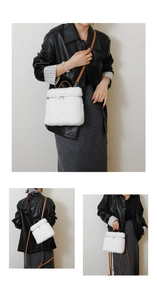 Details van de witte pluchen crossbodytas met bruine lederen riemen en metalen rits