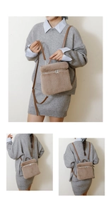 Detail van bruine pluche bucket bag met zilveren rits en lederen schouderbanden