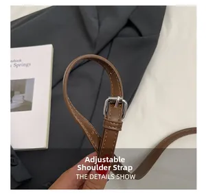 Detail of adjustable brown leather strap with silver metal buckle and multiple adjustment holes