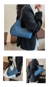 Detail view of deep blue hobo shoulder bag showing matte texture and moon shape