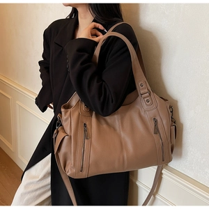 Detail view of large brown lychee grain leather tote bag with vertical zip pockets