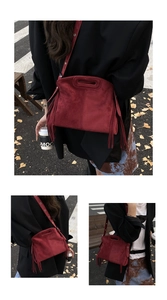 Detailaufnahme der weinroten Wildledertasche mit langen Fransen und geometrischem Griff