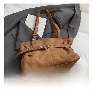 Détail du sac cabas en cuir givré marron avec une boucle de ceinture réglable décorative