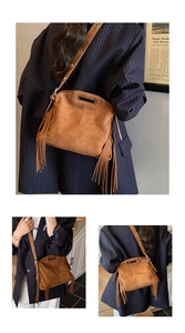 Detail einer braunen Wildleder-Umhängetasche mit Retro-Fransen und Metallösen-Gurt