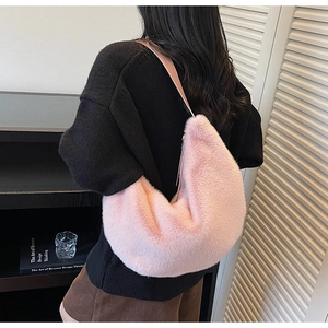 Vue détaillée du sac hobo croissant en fausse fourrure rose dans un décor intérieur