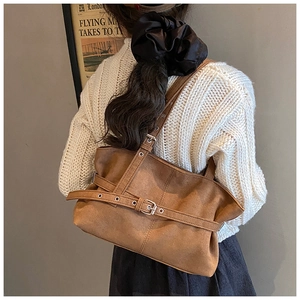 Détails macro d'un sac cabas en daim marron vintage avec boucles et plis souples