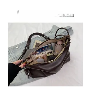 Detail view of large brown leather tote bag showing internal storage for iPad and essentials