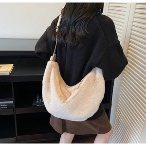 Détail du sac hobo en peluche beige avec bandoulière réglable porté par un mannequin