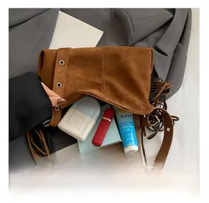 Brown suede shoulder bag interior showing large capacity for daily essentials and tassels