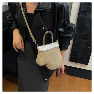 Detail of mitten-shaped faux suede bag with soft white sherpa trim and shoulder strap