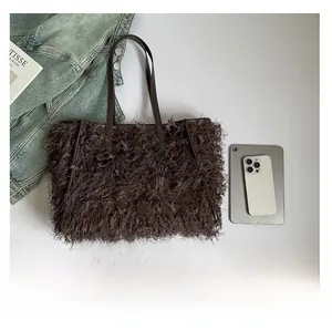 Vue détaillée du grand volume du sac cabas en plumes marron foncé avec des accessoires