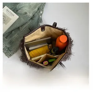 Intérieur spacieux du sac en peluche marron avec parapluie, tablette et objets du quotidien