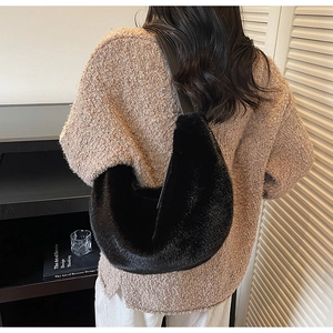 Vue détaillée du sac croissant en fausse fourrure noire sur un modèle montrant la texture