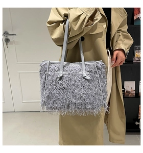Détail d'un sac cabas gris en fausse fourrure avec franges texturées et anses fines en cuir